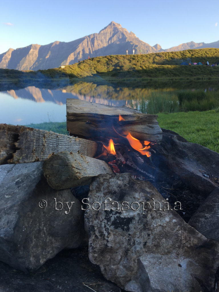 Feuerstelle vor See und Bergmassiv