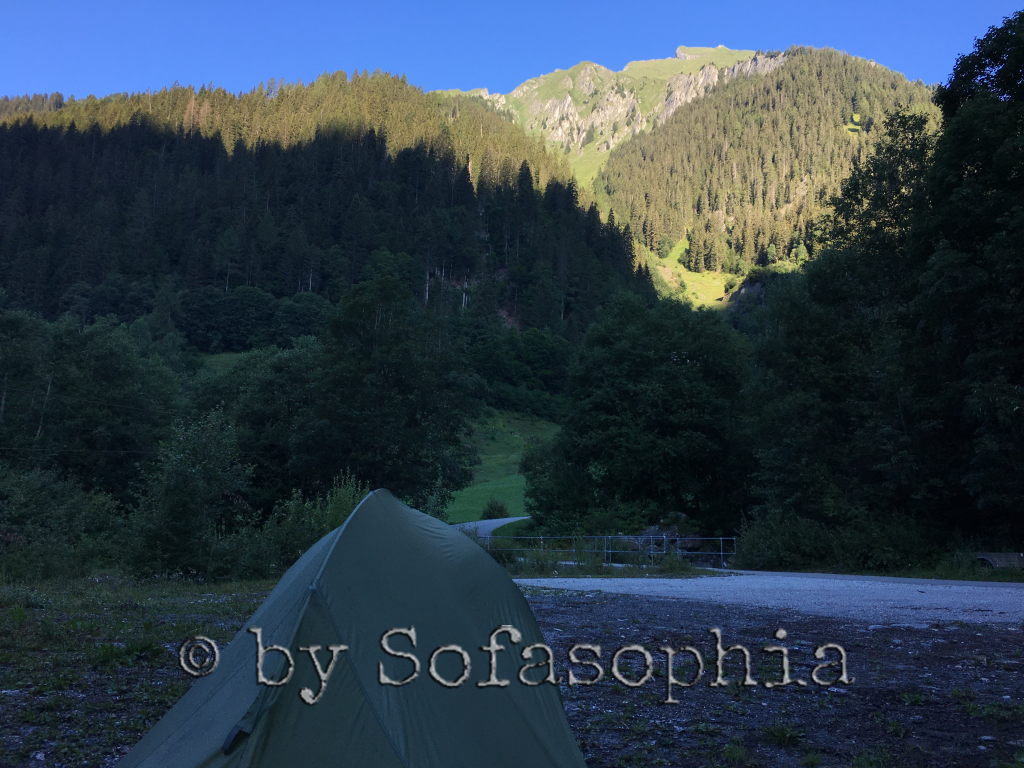 Die Sonne erreicht bereits ein bisschen mehr Land, doch beim Zelt im Vordergrund ist noch immer Schatten.