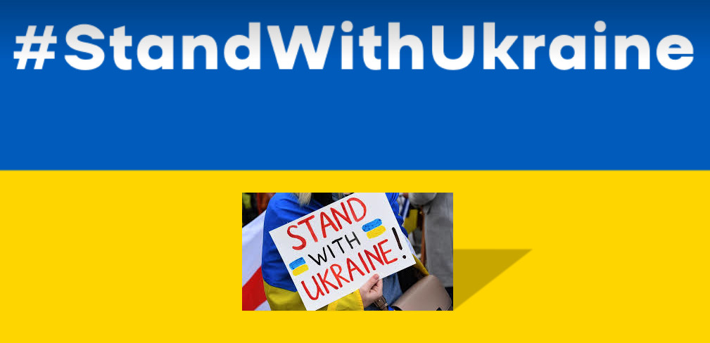 Ukrainische Flagge mit dem Satz Stand with Ukraine in weißer Schrift, im gelben Feld eine Fotografie eines Plakats mit dem gleichen Satz