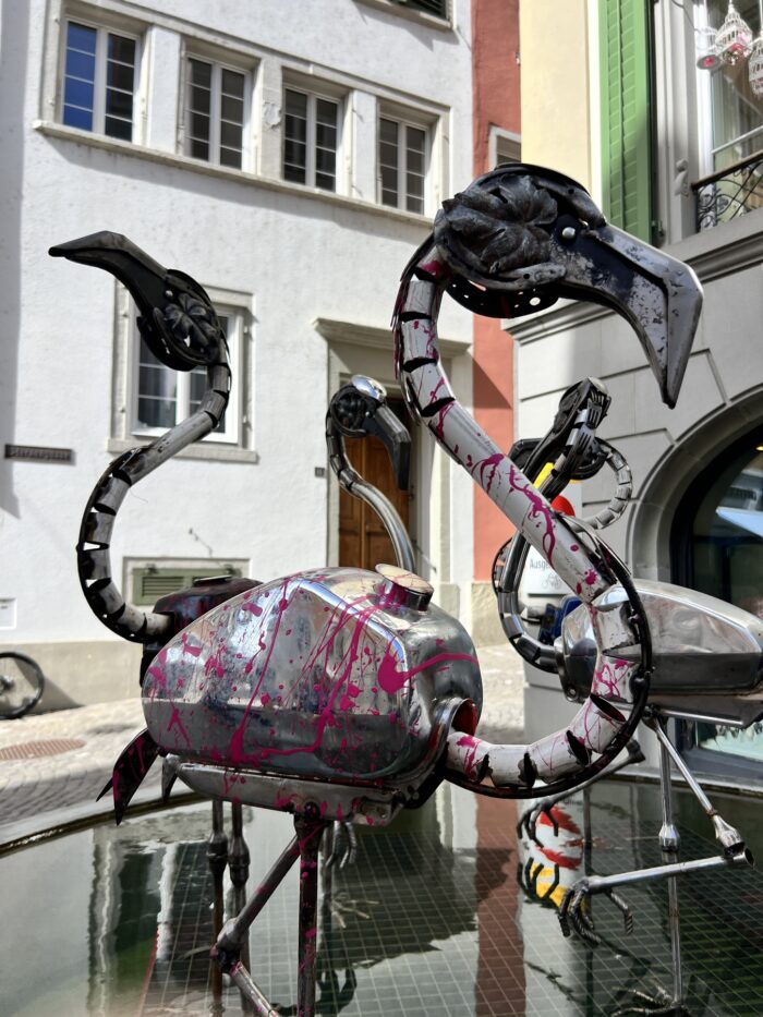 Eine kunstvolle Brunnenfigur: Ein blecherner Pelikan, dessen Körper aus einem Mofamotor gebaut wurde